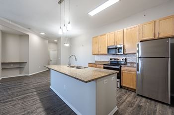 A kitchen with a granite countertop and stainless steel appliances at Vistas at Jackson Creek, Monument, Colorado